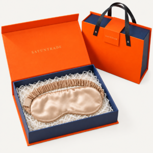 Silk sleep mask presented in an orange and navy gift box with matching gift bag