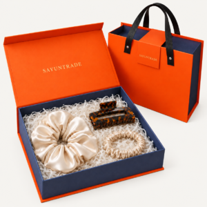 Three-piece gift set with an acetate claw clip, large silk scrunchie and slim silk scrunchie in orange and navy gift packaging